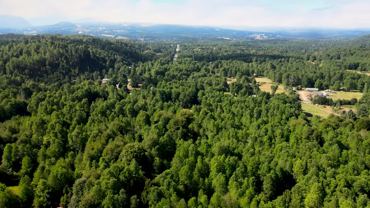 panorámica aérea a la izquierda bajando en la laguna azul escondida entre un denso bosque verde cerca de los ojos de caburgua, pucón, chile