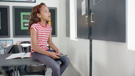 Biracial girl with brown hair sits in a classroom, looking tired with eyes closed, in school