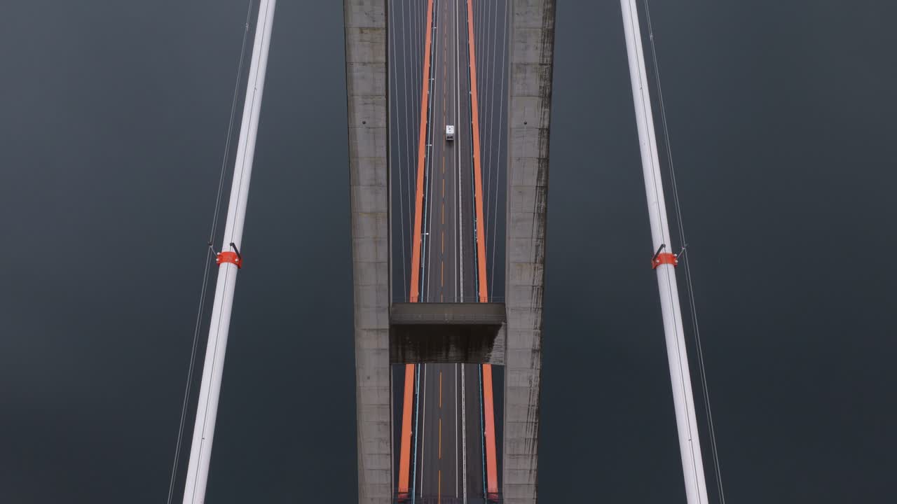Ripresa aerea in una giornata uggiosa di auto che attraversano il Ponte di Hardanger in Norvegia sopra il fiordo