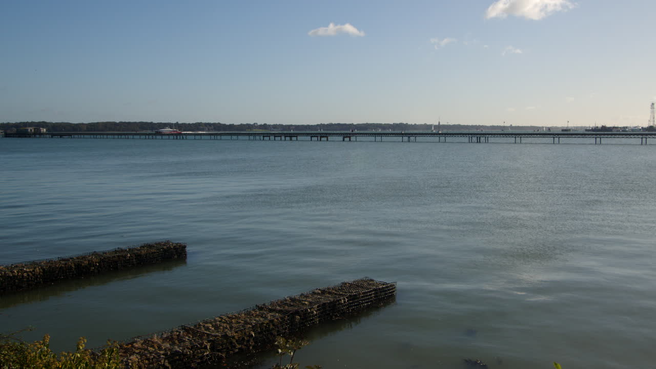 el muelle del ferrocarril con el ferry de catamarán en el fondo, tomado de la marina de hythe