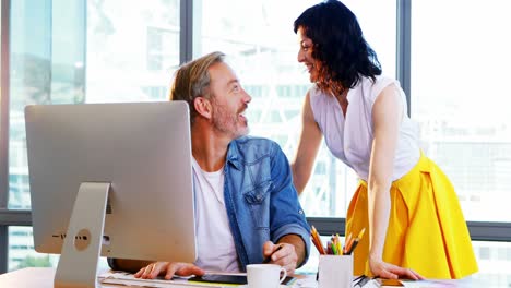 male and female graphic designers working together at desk