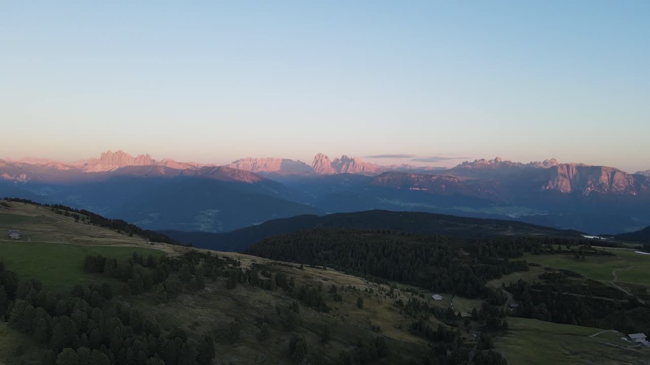 ripresa aerea con drone delle alpi durante il tramonto con capanne e terreni agricoli, bellissima natura