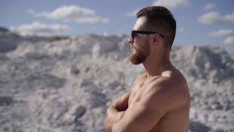 portrait of muscle man posing outdoor. strong man with naked torso standing on nature