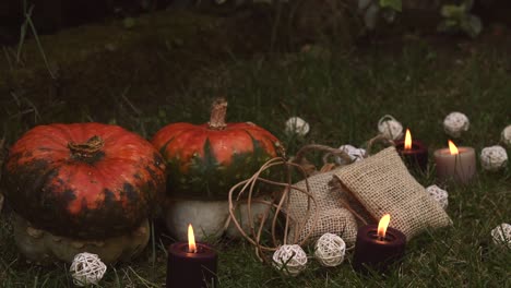 Herbstlicher-Hintergrund-Mit-Kürbissen-Und-Kerzen-Mit-Flammen,-Die-Sich-Im-Wind-Bewegen