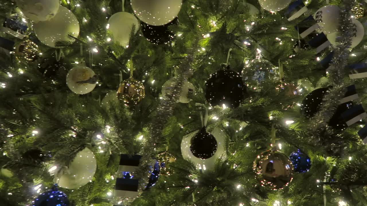 close up of a christmas tree decorations with lots of lights glowing softly between the branches and estonian flags