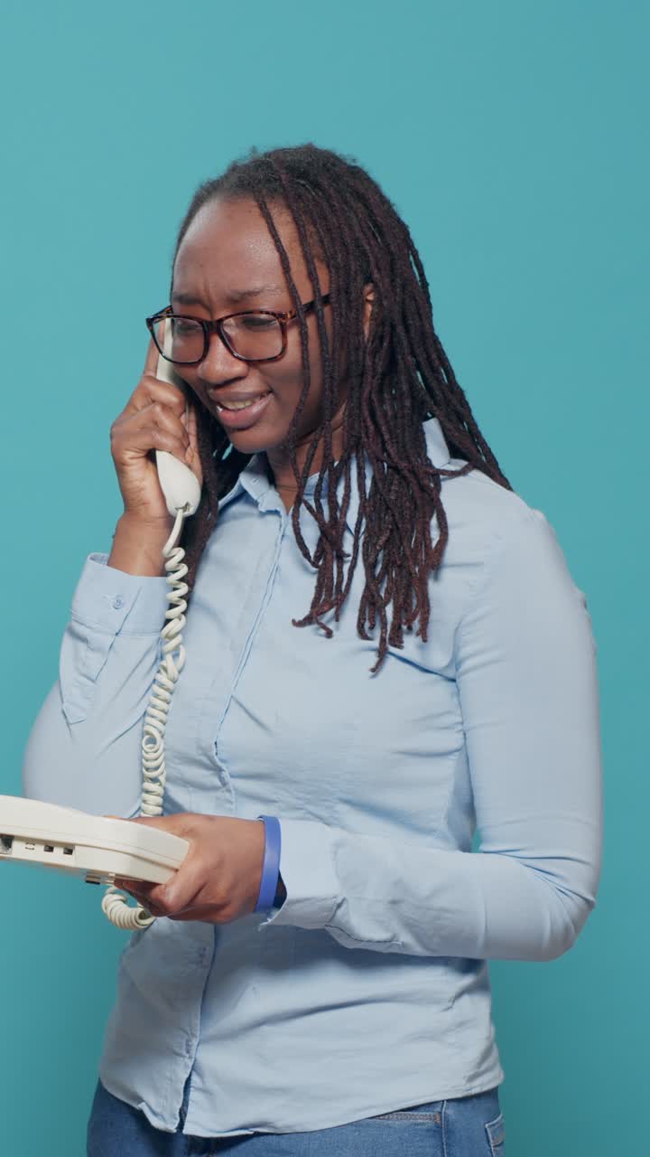 Kvinde der taler i en fastnettelefon