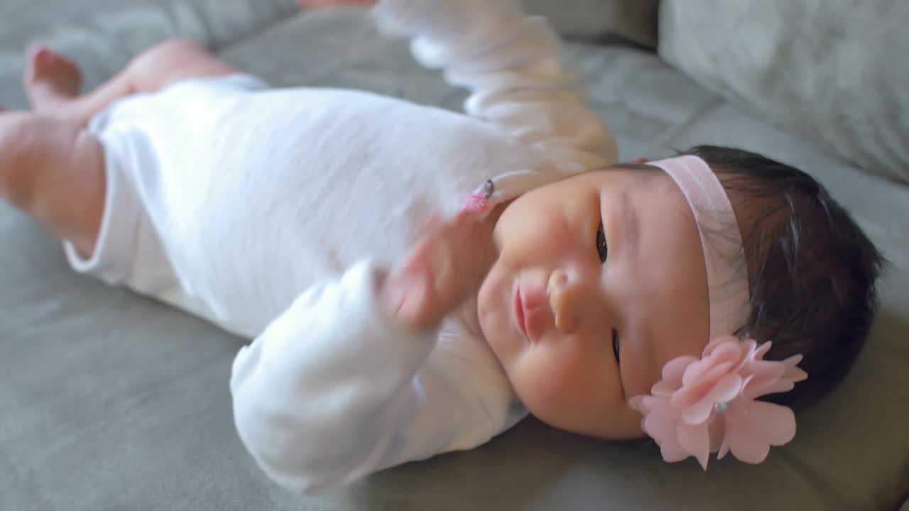 un bebé recién nacido moviéndose acostado en un sofá