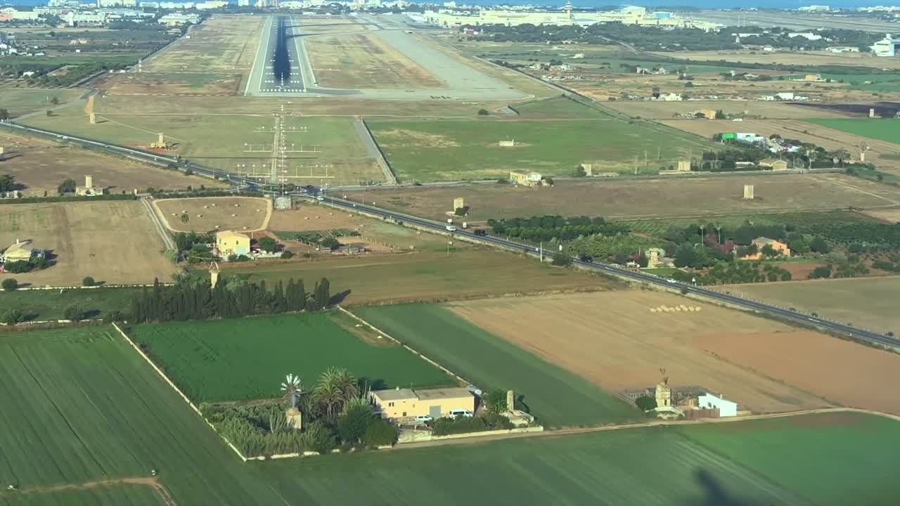 a cockpit view of the sahdow of a jet airplane approching to the runway for landing, as seen by the pilot from cockpit. Early morning light, hazy day. Palma de Mallorca Airport.