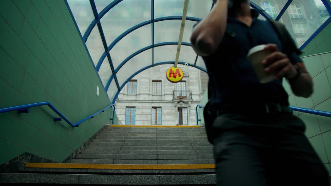 A man walking up stairs in a Warsaw Metro station