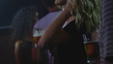 woman raising beer mug at bar with ambient lighting, showing animated marketing sales chart