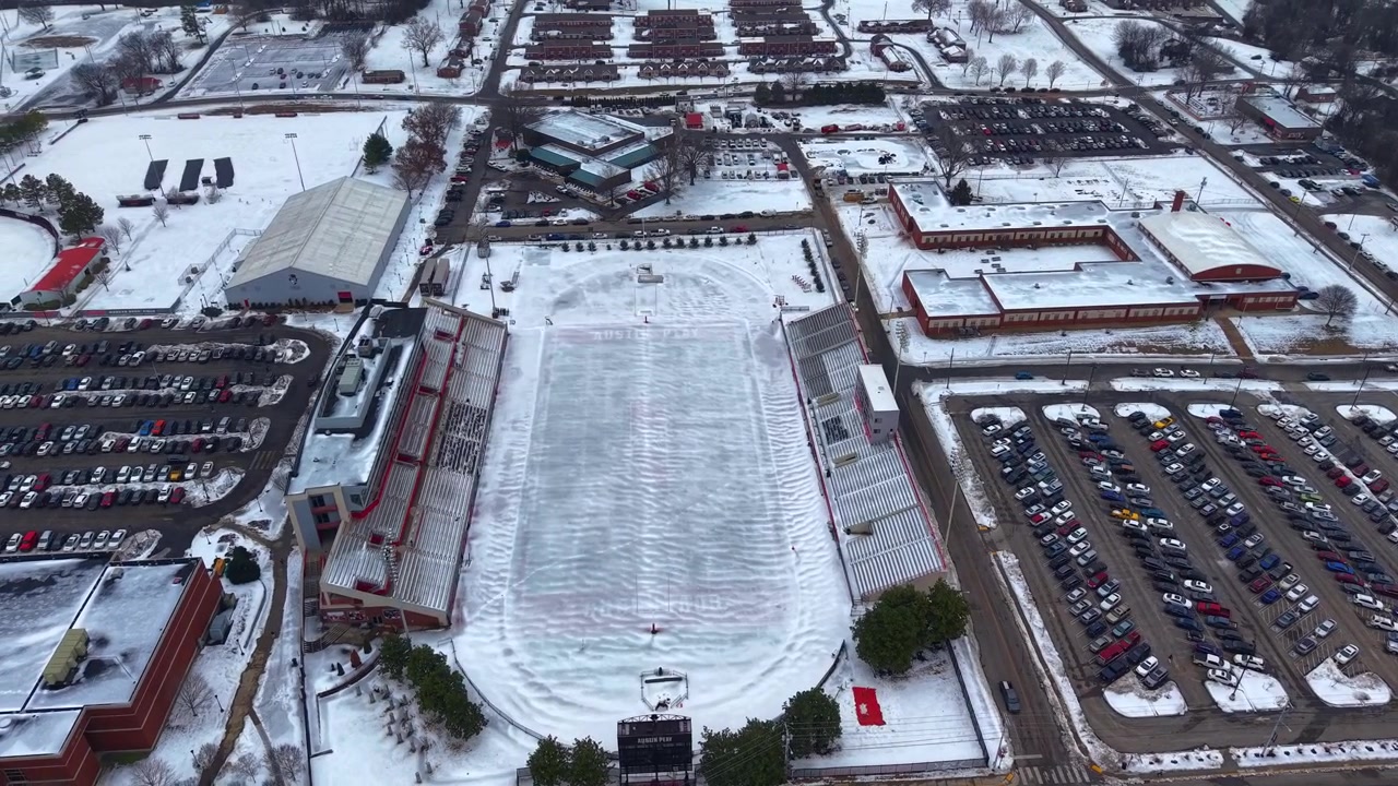 Ripresa aerea con drone in orbita del campo da football dell'Università Austin Peay a Clarksville, Tennessee, con uno spesso strato di neve che copre il campo.