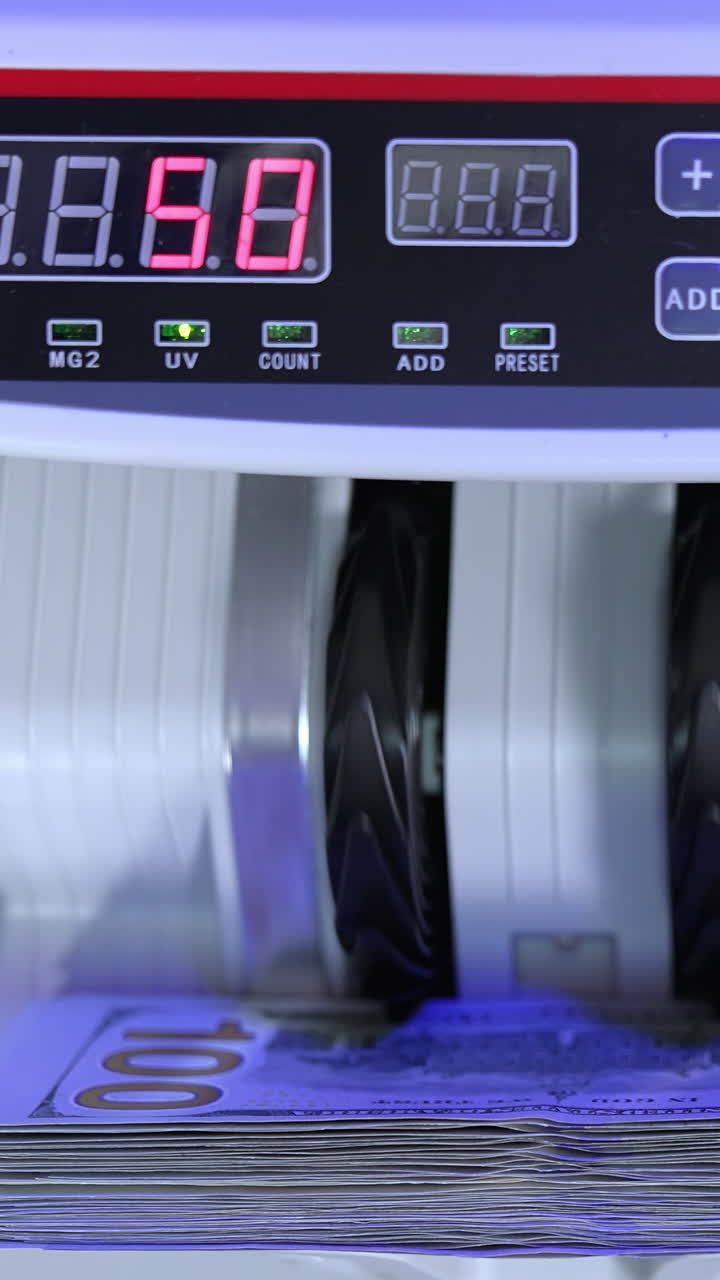 Money counting equipment for paper money calculation. Automatic mechanism for bank financial operations. Currency exchange of one hundred dollars. Close-up. Vertical video