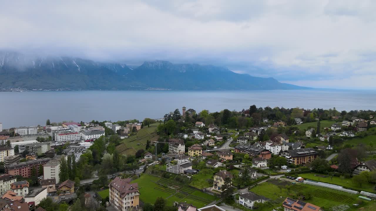 полет над городом монтре в швейцарии в бурный день с женевским озером и альпами на заднем плане