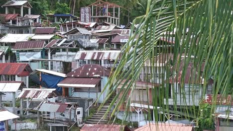 Bacuag-Catholic-Cemetery-in-Surigao-Del-Norte,-Philippines-aerial-shot-reveal-from-palm-tree