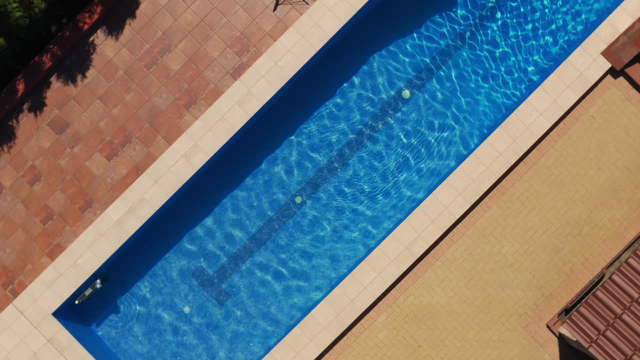 Orbitalt luftfoto over en lineær swimmingpool på et smukt resort.