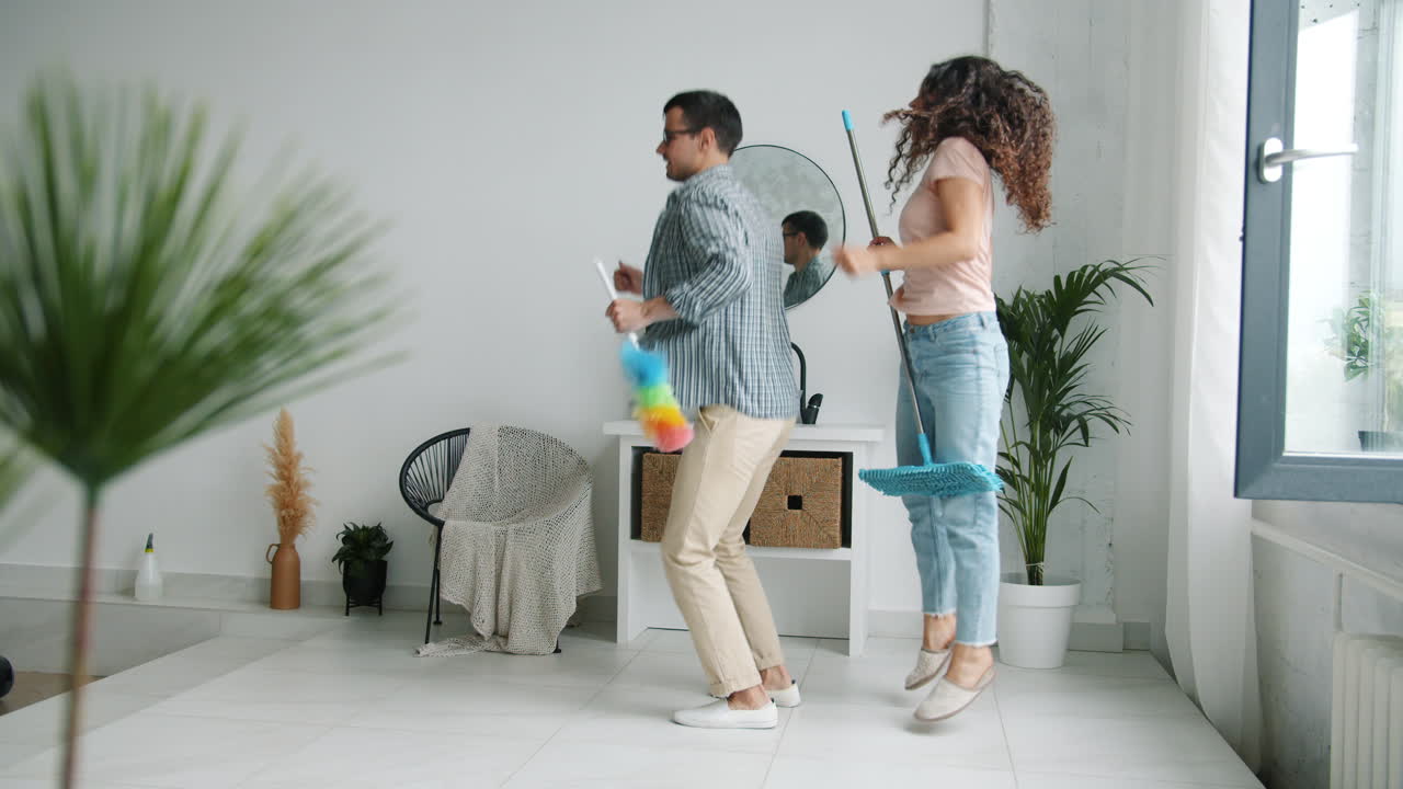 pareja bailando mientras limpia