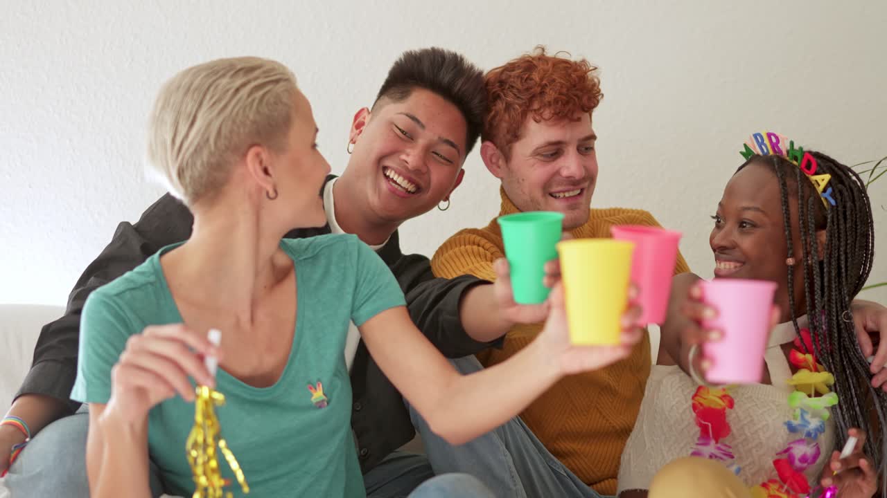 Diverse friends celebrating a birthday party with colorful cups
