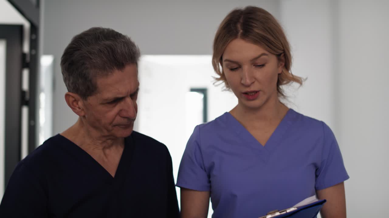 dos médicos caucásicos analizando exámenes médicos.