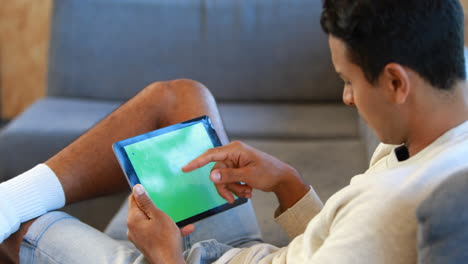 Man using a tablet sitting on the couch