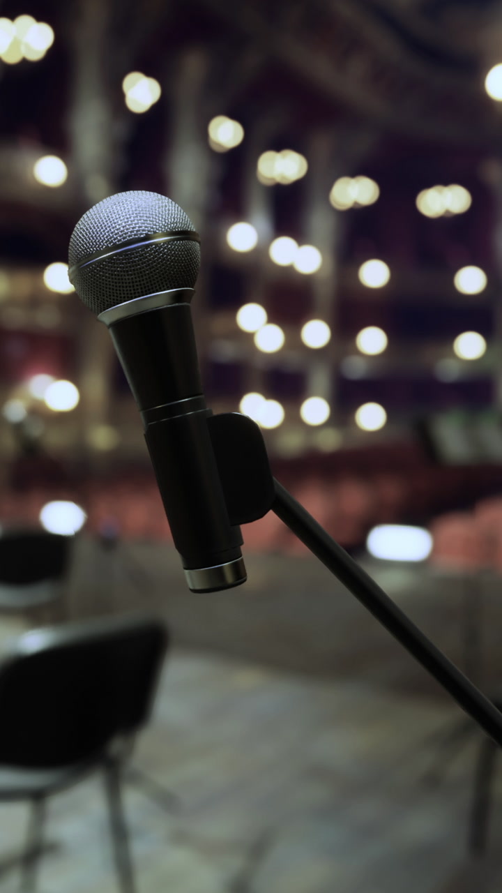 Microphone stands ready on stage before a performance in a theater