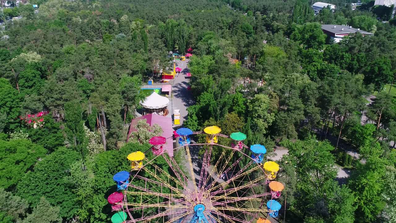 vista inferior o lateral desde el suelo de una rueda de ferris sobre el cielo azul. fragmento brillante y colorido de la rueda de ferris en movimiento en verano.