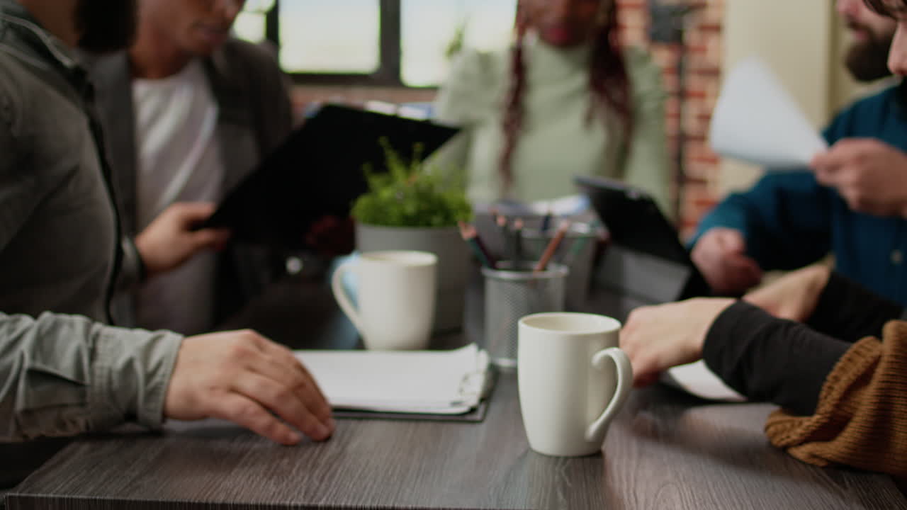 Diverse team of coworkers looking at rate charts on papers