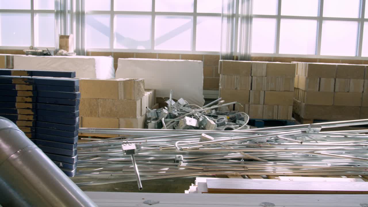 Construction site dolly right to left of pipes and wood