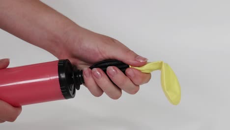 a sequence showing a yellow balloon being inflated using a red hand pump.