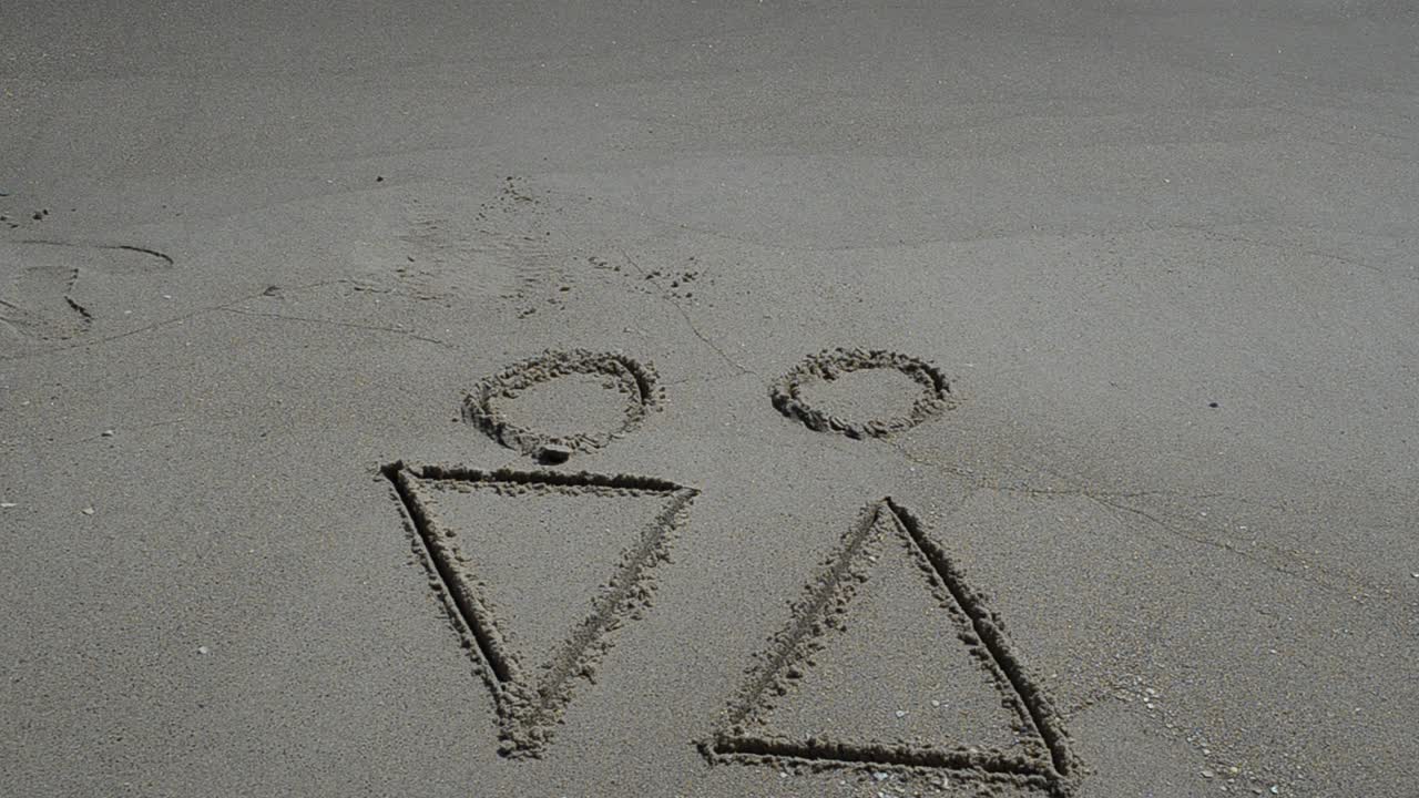 Disegno sulla sabbia che raffigura l'amore tra sessi opposti. Riprese in spiaggia.