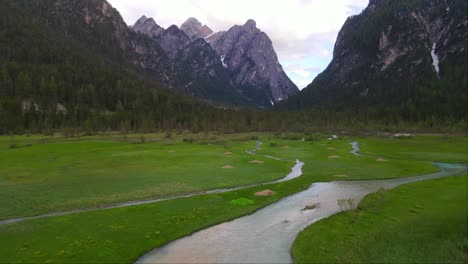 fotografía de un avión no tripulado de un río sinuoso cerca del lago dobbiaco en toblacher see, tirol del sur, italia