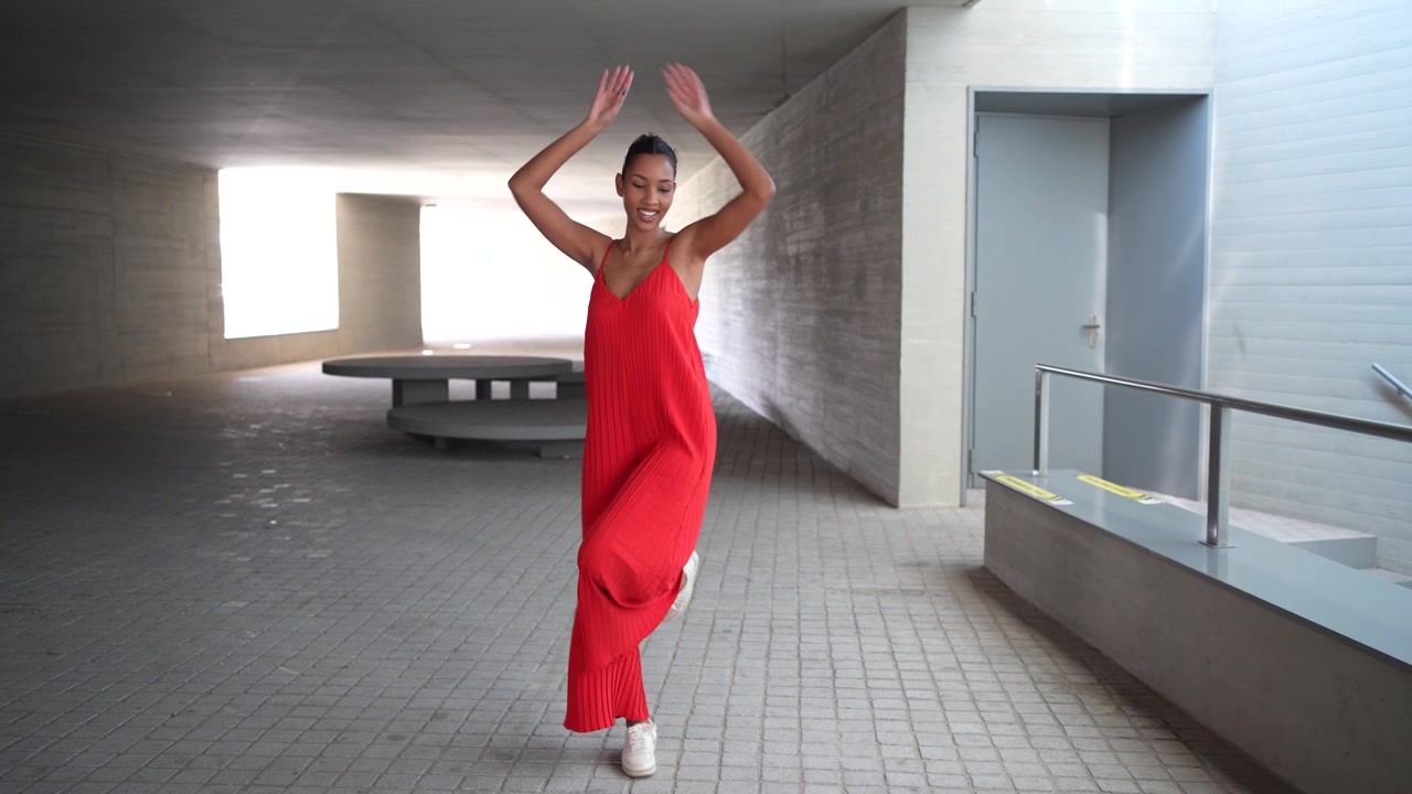 An elegantly captivating dance pose displayed in a stunning and vibrant red dress