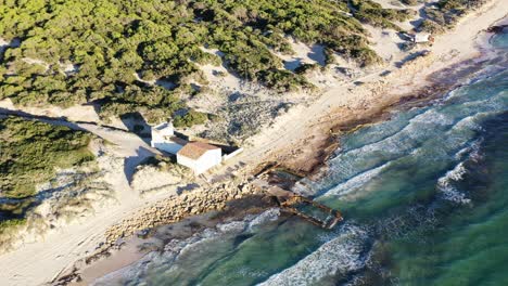 Playa-De-Trenc-En-Mallorca-España-Con-Un-Pequeño-Bar-Restaurante-Cerca-De-Una-Estructura-De-Edificio-Recuperada-Junto-Al-Mar,-Vista-Aérea-Aérea