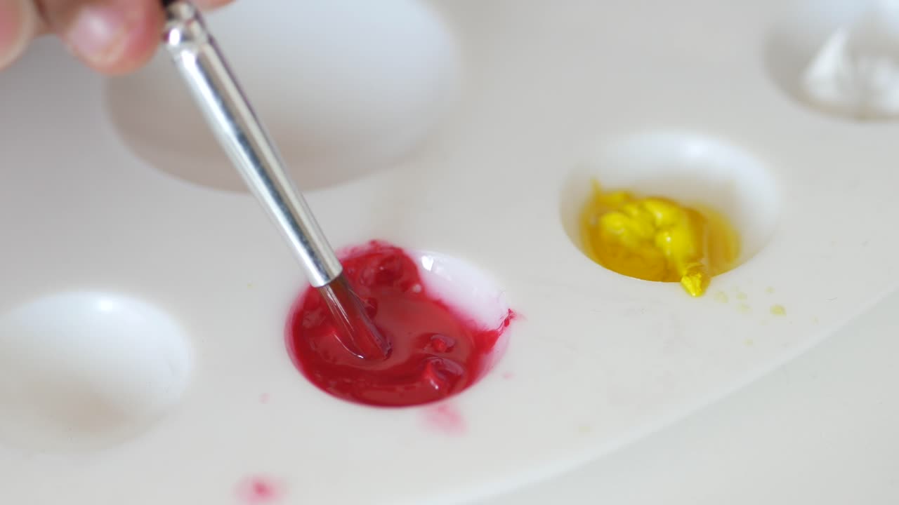 Mixing Red and Yellow Paints on a Palette
