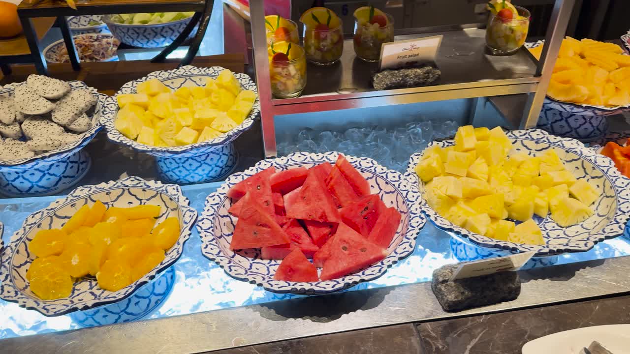 una vibrante exhibición de frutas variadas en un buffet en un complejo turístico de phuket, con iluminación brillante y una atmósfera acogedora