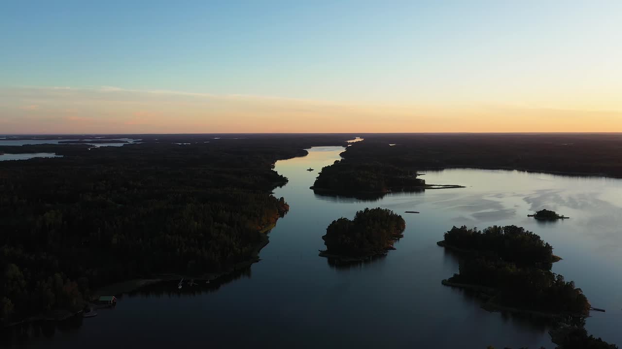 Aerial view overlooking islands, in the Estonian archipelago, during a colorful, summer sunset, at the Baltic sea, in West Estonia - tracking, drone shot