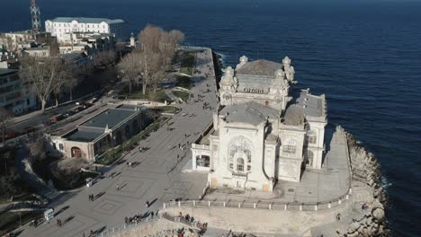 Historical-casino-building-by-the-sea-cliff---Constanta,-Romania---Aerial-shot-outward-move