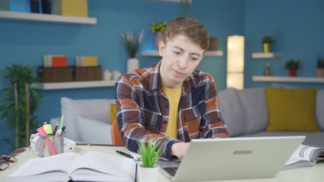 un estudiante infeliz mirando su computadora portátil.