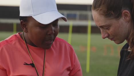 Young-adult-female-rugby-player-and-coach-at-training