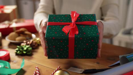 Eine-Frau-Dekoriert-Eine-Weihnachtsgeschenkschachtel,-Während-Sie-Auf-Der-Couch-Sitzt.-Frauenhände-Packen-Ein-Neujahrsgeschenk.-Eine-Frau-Dekoriert-Eine-Weihnachtsgeschenkschachtel,-Während-Sie-Auf-Der-Couch-Sitzt.