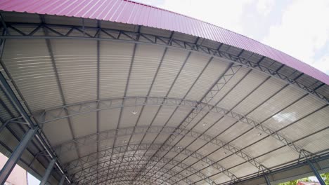 a huge roof protects cars in a parking lot from the elements - tilt up view