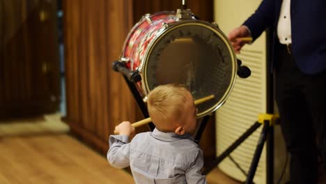 niño con enfermedad de autismo haciendo actuación de baterista y devolviendo herramientas a baterista profesional