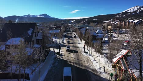 Aerial-view-over-a-snow-covered-rural-neighborhood-in-valley-on-a-sunny-day