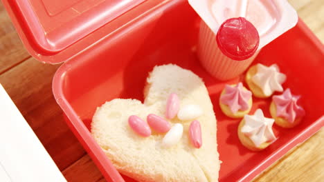 primer plano de un pastel en forma de corazón con piruleta