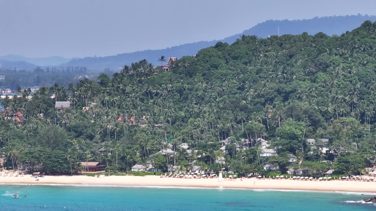 Pansea Beach with palm trees and umbrellas for tourists in Phuket, Thailand. Drone panoramic.