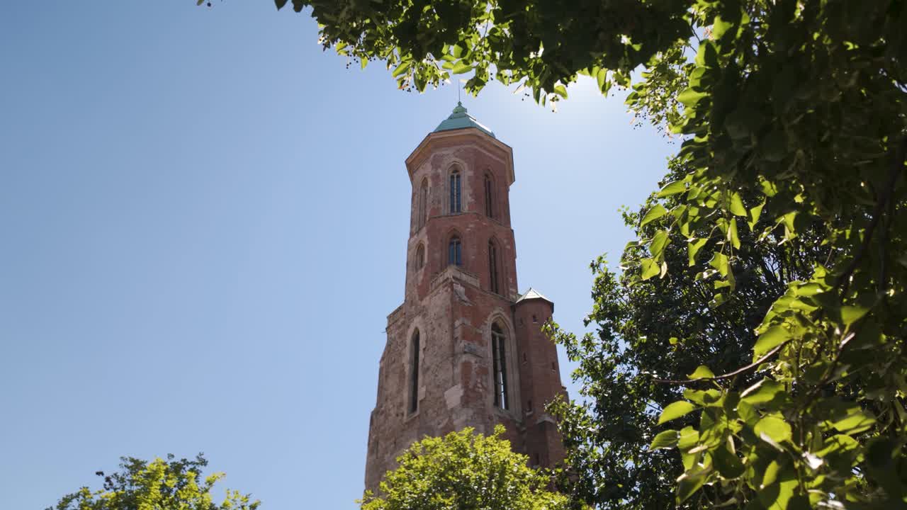 Historic tower of Saint Mary Magdalene Church standing against a clear blue sky. tilt up