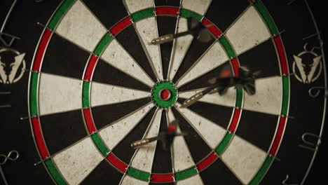 a dart being thrown at a dart board and a hand grabbing the dart