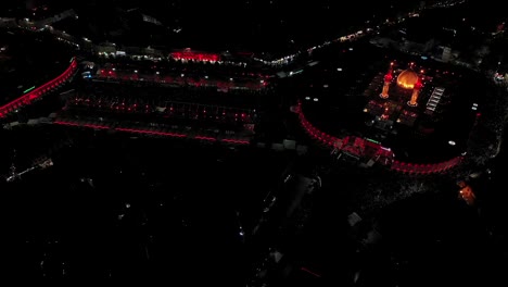 a night shot by a drone of shiite visitors and pilgrims at the mosque and shrine of imam hussein and abbas in karbala, iraq
