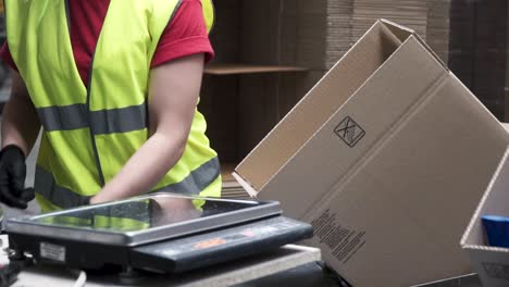 warehouse worker packaging and weighing cartons