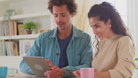 couple with credit card at home use digital tablet to review finances for starting business