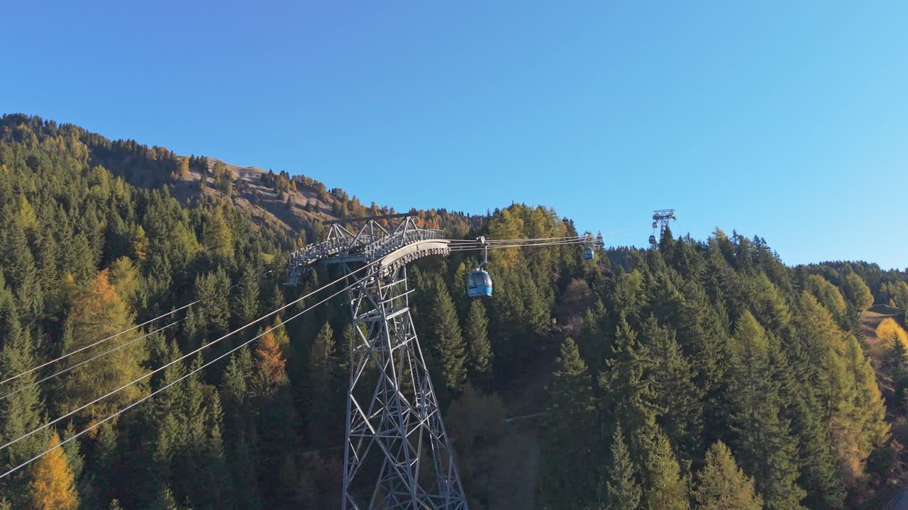 Funivia che scende da una montagna delle Dolomiti in una giornata di sole, vista aerea